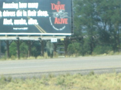 1990 Ford Bronco - blurry roadside billboard for Drive Alive warns about drivers dying in their sleep, stay alert awake alive.