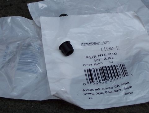 1990 Ford Bronco - A black nylon hole plug is shown on its packaging, which details its size and manufacturer.