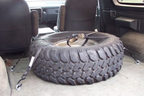 1990 Ford Bronco - Spare tire is strapped down in the cargo area of a 1990 Ford Bronco.