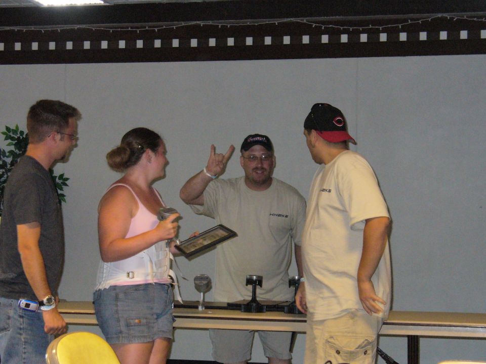 People gathered around a table with trophies