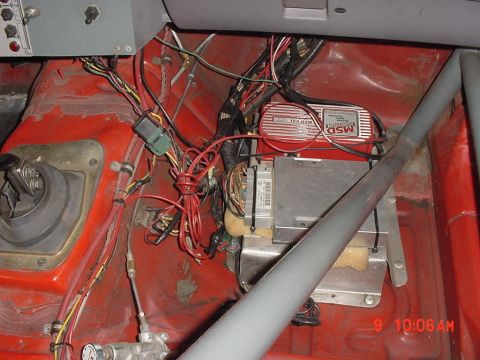 1993 Ford Mustang - The interior of a car shows a complex wiring harness and aftermarket electronic components.