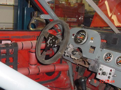1993 Ford Mustang - Interior view of a modified vehicle, a steering wheel, roll cage, and multiple gauges.