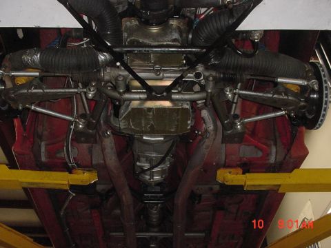 1993 Ford Mustang - The underside of a red vehicle is captured, revealing its mechanical components and suspension system.