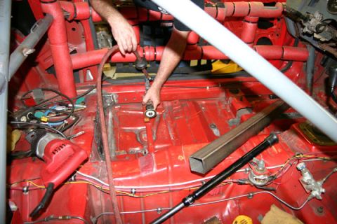 1993 Ford Mustang - Interior of a car undergoing modifications, showing exposed floor and roll cage.