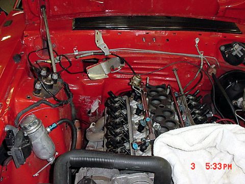 1993 Ford Mustang - The engine bay is red and appears to be undergoing some maintenance or repair work.