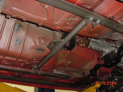1993 Ford Mustang - The undercarriage of a vehicle shows a custom roll cage being welded to the frame.