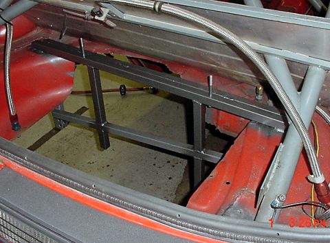 1993 Ford Mustang - Custom metal bracing and roll cage installed in the trunk of a red car, with visible wear and tear on the interior panels.