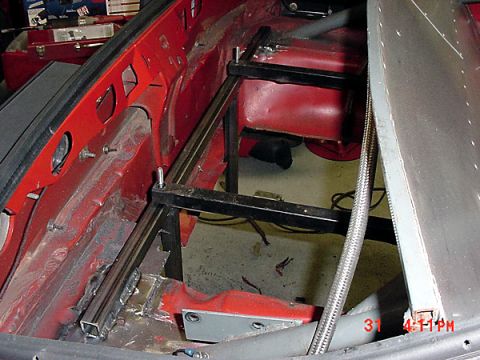 1993 Ford Mustang - Custom metal bracing is installed in the interior of a red vehicle during a rebuilding process.