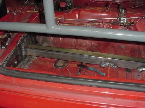 1993 Ford Mustang - Interior view of a car undergoing modifications with a roll cage and welded metal supports.