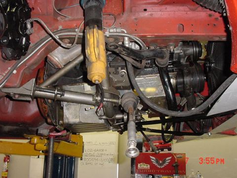 1993 Ford Mustang - Close-up of a vehicle's engine and suspension system, lifted for maintenance.