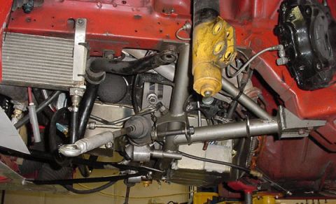 1993 Ford Mustang - Close-up of a car's mechanical components, including suspension and an oil cooler, viewed from below.