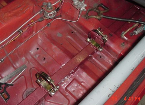 1993 Ford Mustang - Interior floor of a car undergoing modification, with visible brake lines and a roll bar.