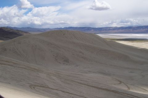 1994 Ford F-150 - Tire tracks mark the sandy terrain of a vast desert landscape under a cloudy sky.