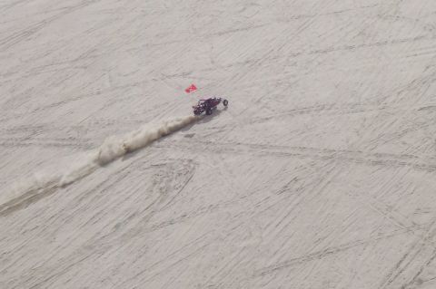 1994 Ford F-150 - A dune buggy speeds across a sandy landscape, leaving a trail of dust behind it.