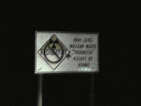 1990 Ford Bronco - Nighttime photo of a roadside warning sign prohibiting high-level nuclear waste except by permit.