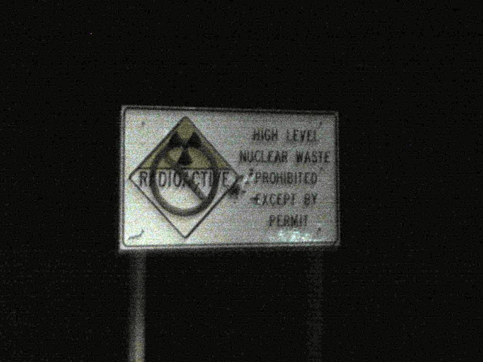 Roadside sign reading 'Radioactive - High Level Nuclear Waste Prohibited Except By Permit'