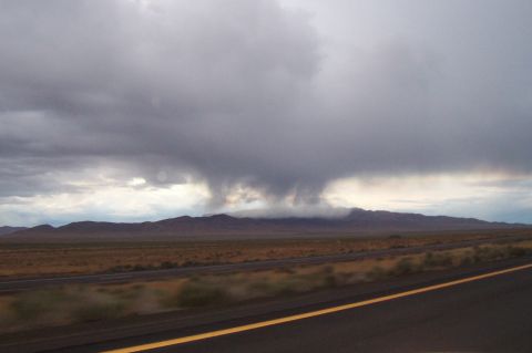 1994 Ford F-150 - A dramatic sky looms over a desert landscape, with a highway stretching into the distance.