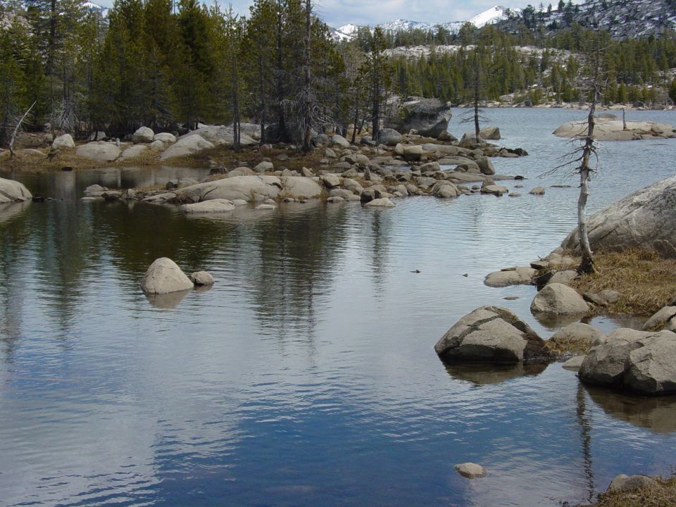 Mountain lake with trees and rocks, Supermotors.net logo in corner