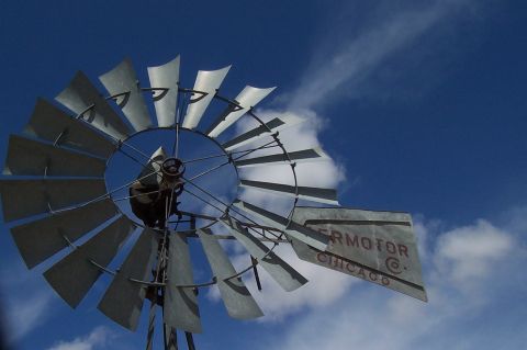 1994 Ford F-150 - A windmill with 'SUPERMOTOR CHICAGO' visible on its tail against a cloudy blue sky.