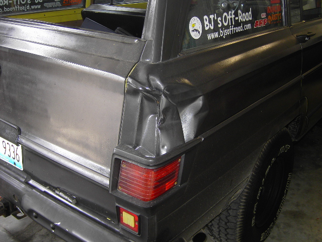 1977 Jeep Wagoneer rear quarter panel shows significant damage near the taillight. License plate 9336 is visible