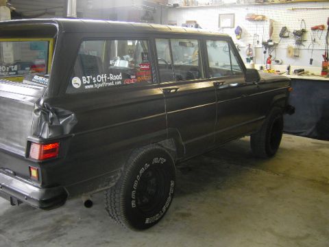 1977 Jeep Wagoneer - A black 1977 Jeep Wagoneer is shown in a garage setting, a "BJ's Off-Road" sticker on the rear window.