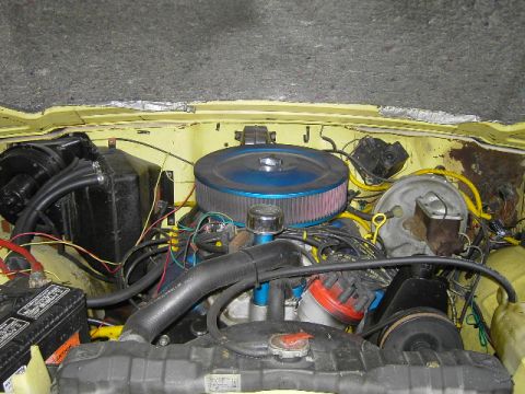 1977 Jeep Wagoneer - The engine bay of a vehicle, showing various mechanical components and wiring under the hood.