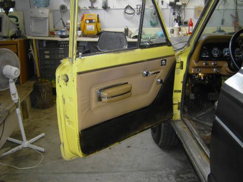 1977 Jeep Wagoneer - The interior of a 1977 Jeep Wagoneer, with its door open, reveals the tan door panel and dashboard details.