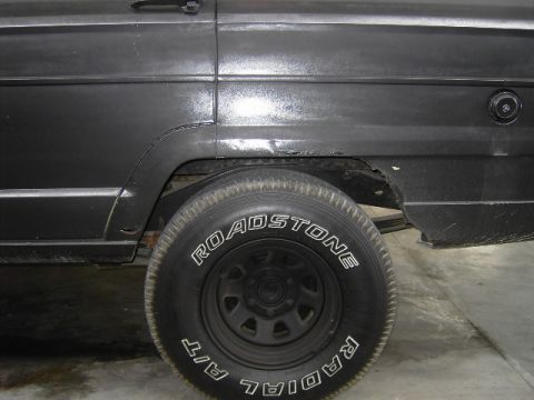 1977 Jeep Wagoneer - Close-up of the rear wheel well on a 1977 Jeep Wagoneer, showing some rust.
