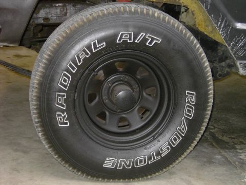 1977 Jeep Wagoneer - A close-up view of a vehicle's tire, showing the brand name and tire type in white lettering.