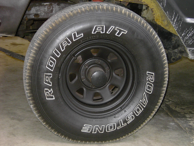 Close-up of a black tire with white lettering that says RADIAL A/T and ROADSTONE