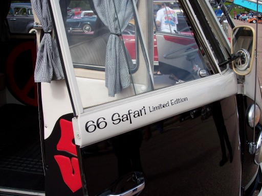 VW bus door lettered '66 Safari Limited Edition' with checked curtains at a car show