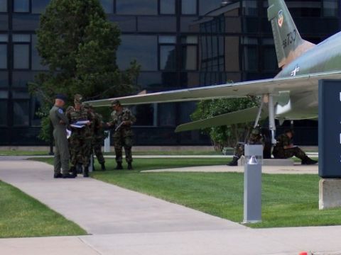 1972 Ford Ranchero - Military personnel gather near an F-100 Super Sabre jet outside a building.