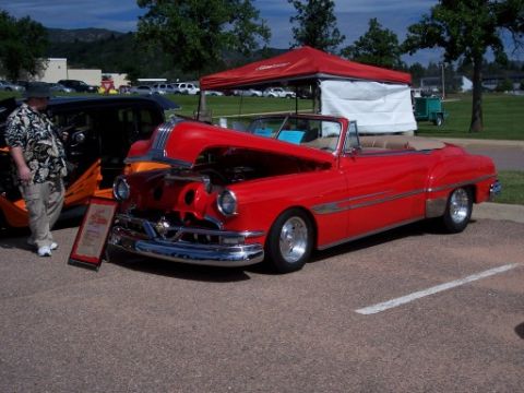 1972 Ford Ranchero - A red convertible with its hood open is parked on asphalt, with a man standing nearby.