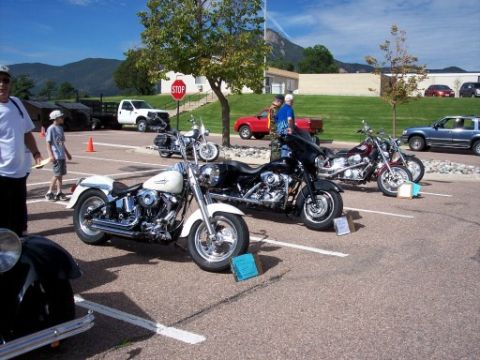 1972 Ford Ranchero - Motorcycles are parked in a lot on a sunny day, with people and other vehicles visible.