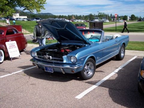 1972 Ford Ranchero - Blue 1965 Ford Mustang convertible, hood open, parked in a lot.