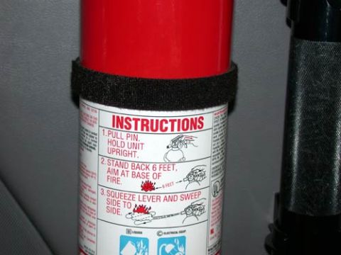 1996 Ford Bronco - Tight close-up of a red fire extinguisher's instruction label reading Pull pin, Stand back 6 feet, Squeeze lever and sweep side to side, wi…