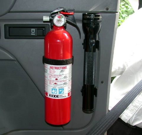 1996 Ford Bronco - A red Kidde dry chemical fire extinguisher and a black Mag-Lite flashlight secured in bracket mounts on a gray molded interior panel, photo…