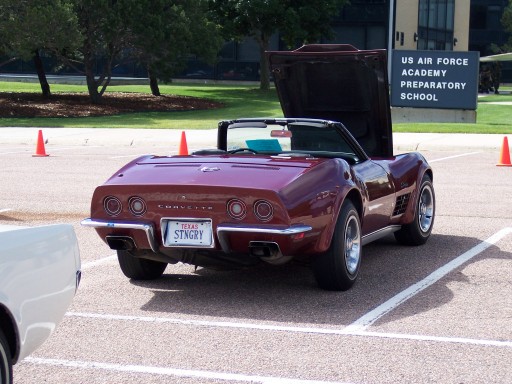 Maroon C3 Corvette convertible with hood up, rear view, Texas STNGRY plate