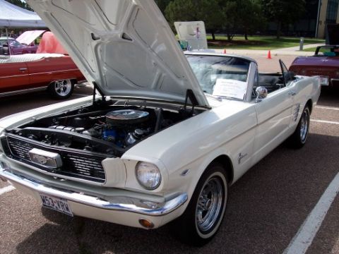 1972 Ford Ranchero - A white 1965 Ford Mustang convertible is displayed with its hood open, revealing the engine bay.