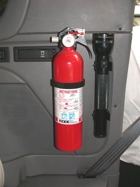 1996 Ford Bronco - Interior detail of a red Kidde dry chemical fire extinguisher and a black Maglite flashlight bracket-mounted to a gray plastic interior tri…