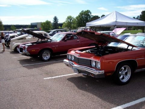 1972 Ford Ranchero - A red 1972 Ford Ranchero is displayed with its hood open at a car show, alongside other vehicles.