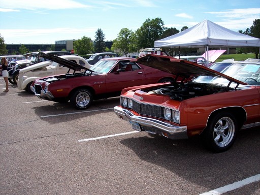Red 1972 Ford Ranchero with hood open, parked at an outdoor event