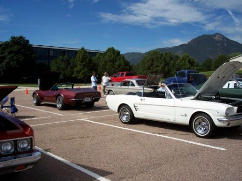 1972 Ford Ranchero - Several classic cars are on display at an outdoor event, with a white convertible prominently featured.