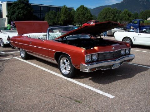 1972 Ford Ranchero - This orange convertible, likely a 1971 model, is parked with its hood open, revealing the engine bay.