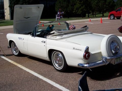 1972 Ford Ranchero - A classic white convertible with its hood up and a spare tire mounted on the rear is parked outdoors.