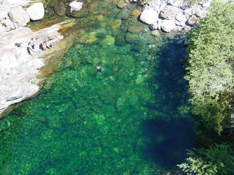 1986 Ford Bronco - A scenic view of a river with people enjoying a swim on a sunny day.