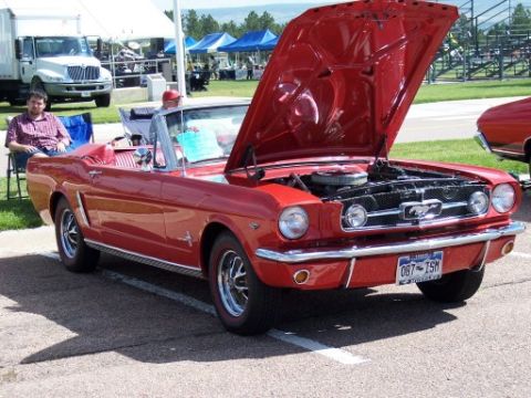 1972 Ford Ranchero - Red 1965 Ford Mustang convertible with hood open at an outdoor event.