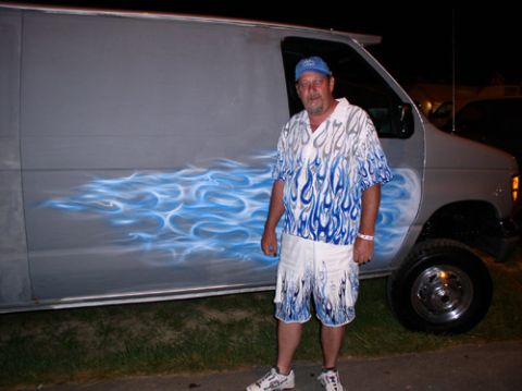 1978 Ford Mustang II - Man poses with a van custom blue flame airbrush art on its side.