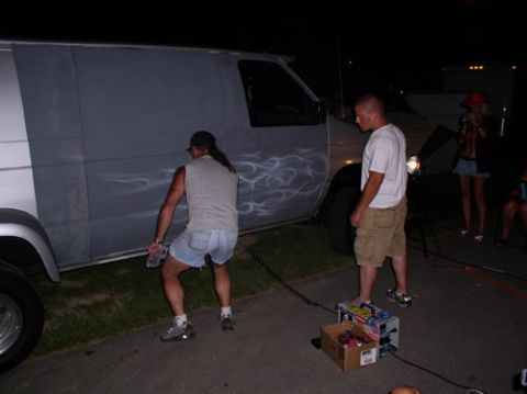 1978 Ford Mustang II - A van with flame decals is being worked on by people at night.