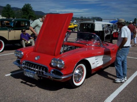 1972 Ford Ranchero - A red 1958 Chevrolet Corvette convertible is displayed with its hood open at an outdoor event.